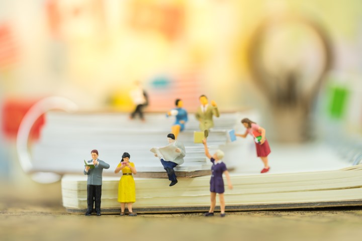 Illustration de l'animation "Lire et relire" : une photographie en gros plan de personnages d'adultes en pâte à modeler posés sur des livres